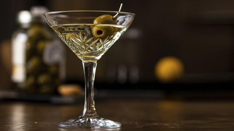 A martini with an olive garnish, in a crystal martini glass