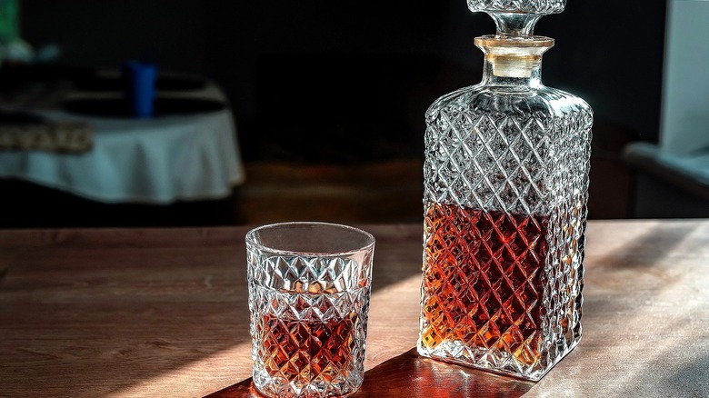 Glass decanter and separate glass filled with cognac