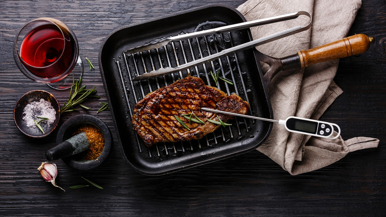 A meat thermometer in a grilled steak.