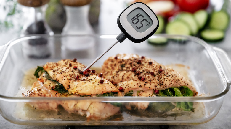 Meat thermometer reading 165 degrees Fahrenheit in cooked chicken