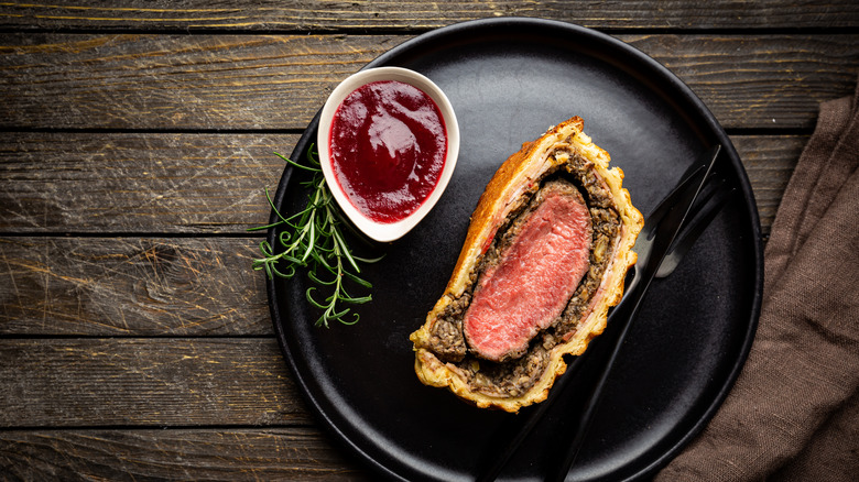 Plated slice of beef Wellington with sauce