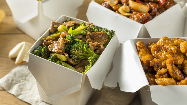 Boxes of Chinese takeout food with broccoli, chicken, and beef