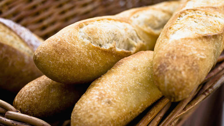 Women brown basket full of baguettes