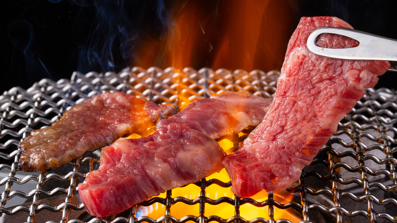 steak on mesh rack over flame