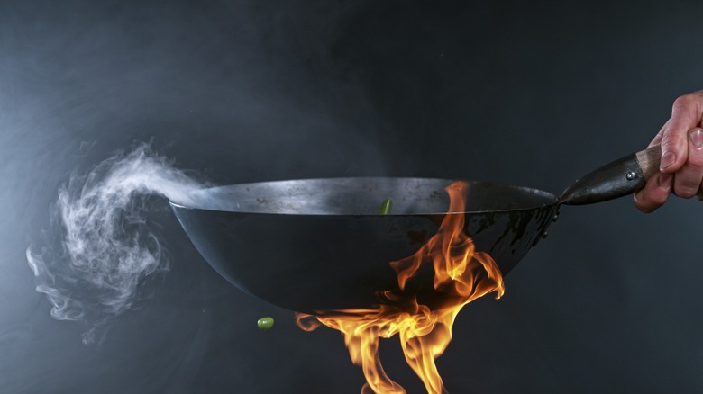 heating wok over flame