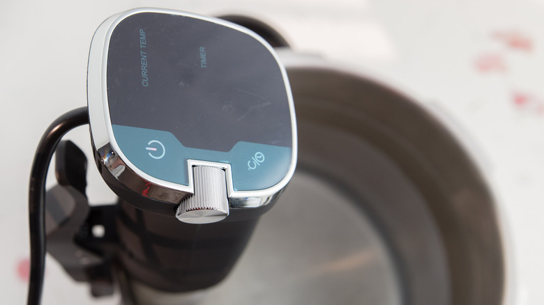 A sous vide heat circulator attached to a pot of water.