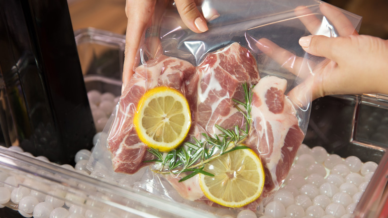 Pork chops in a sous vide bag with lemon and rosemary