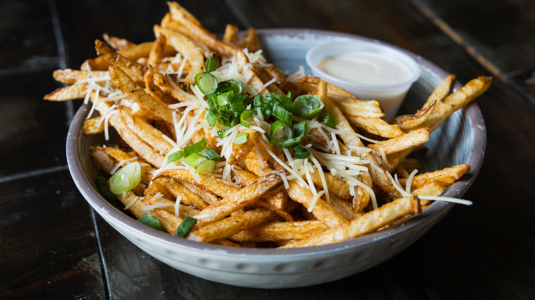 Truffle fries garnished with cheese and scallions