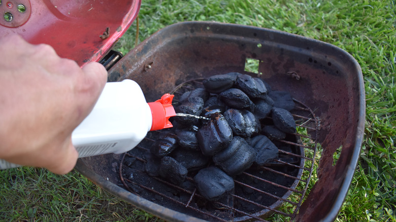 lighter fluid poured onto charcoal grill