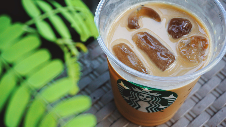 Starbucks coffee and ice cubes in plastic cup with no lid