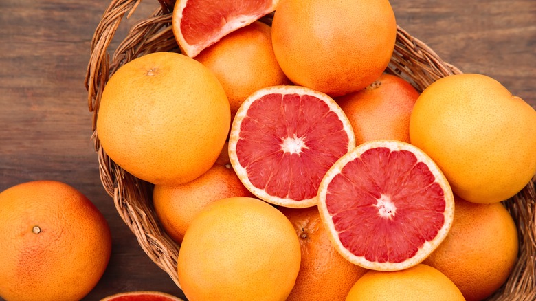 A wicker basket filled with whole and halved grapefruits