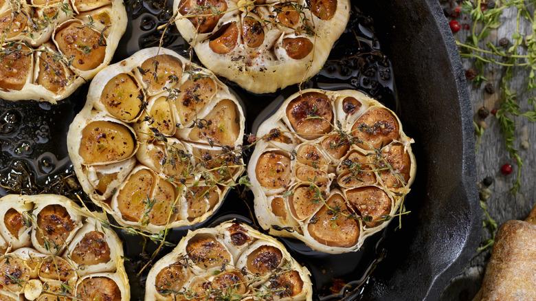 Bulbs of roasted garlic in cast iron skillet