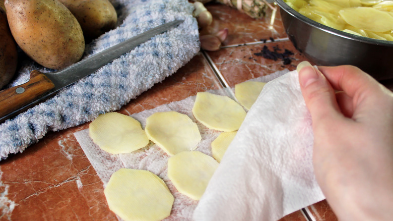 Drying slices of soaked potato before cooking