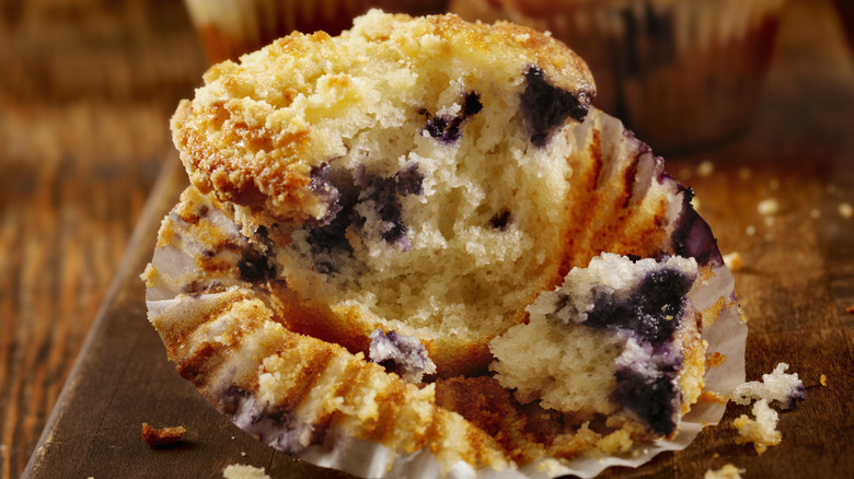 Blueberry muffin partly eaten in wrapper