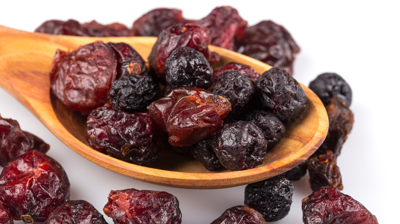 Wooden spoon of dried cranberries, blueberries, and cherries