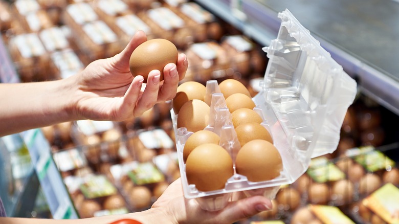 woman selecting eggs at supermarket