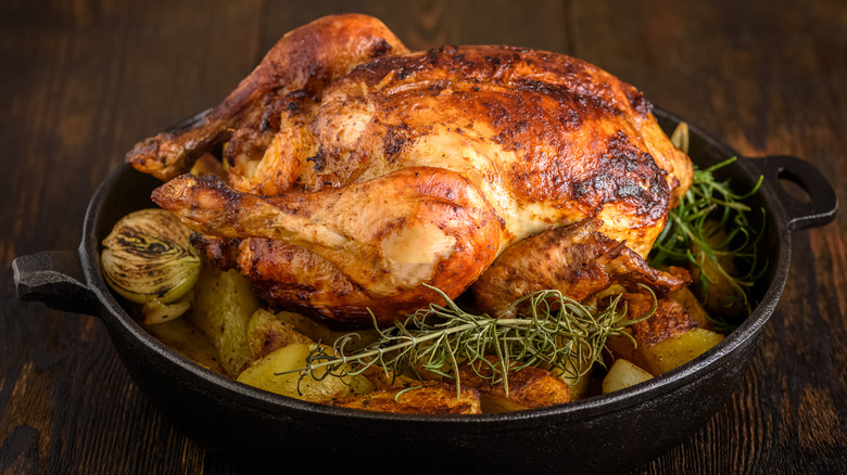 Roast chicken with potatoes and onions in a pan