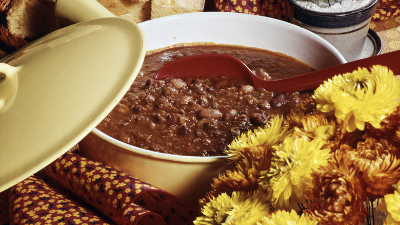 A pot of chili foregrounded by yellow flowers