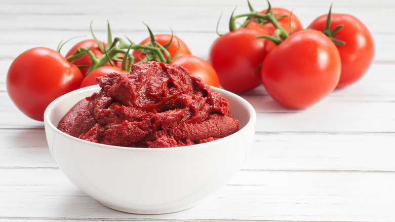 Fresh tomatoes and bowl of tomato paste