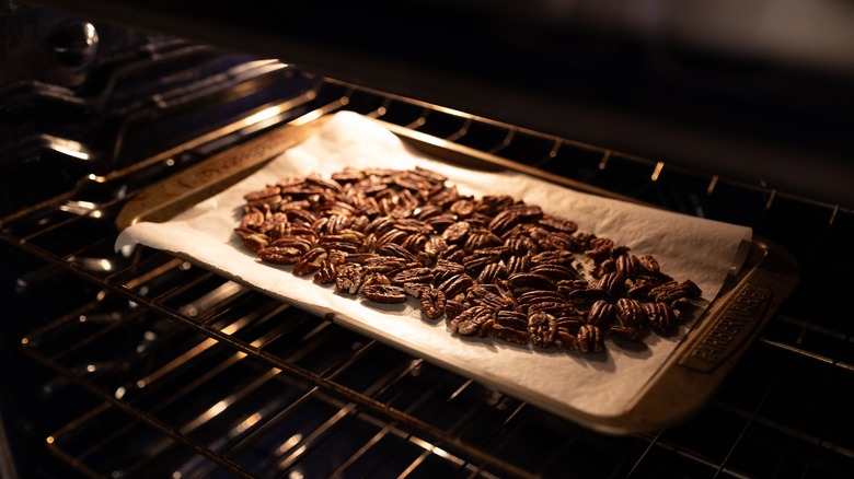 A tray of pecans cooking in the oven