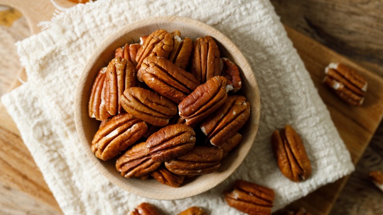 A bowl of pecans on white cloth