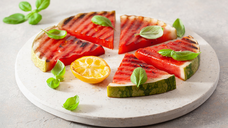 Grilled slices of watermelon with basil and lemon