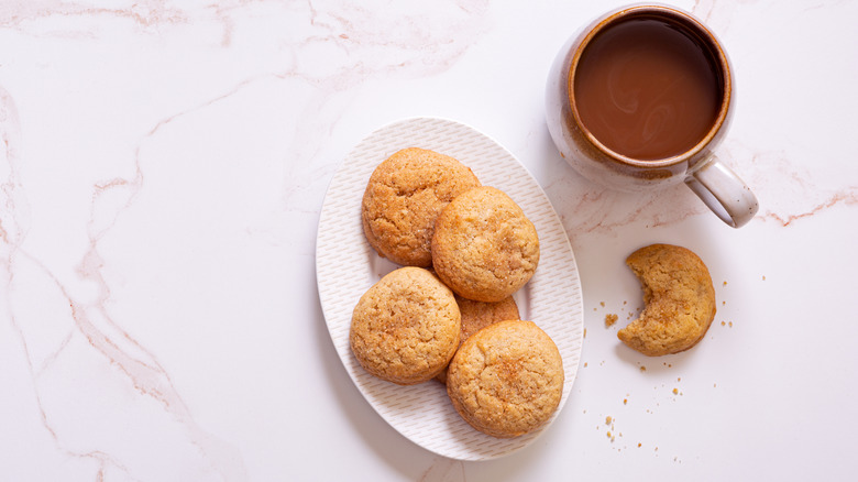 plate full of snickerdoodle cookies with a mug of coffee