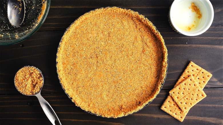 Classic graham cracker crust pressed into a metal pie pan