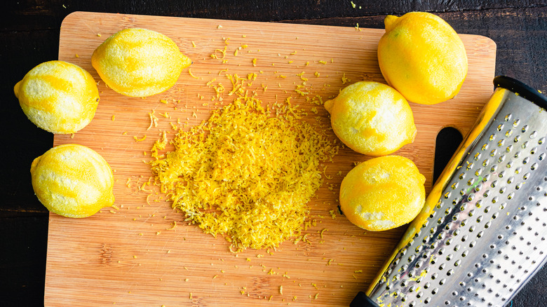 Box grater and lemon zest on cutting board
