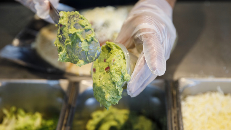 Scooping guacamole at Chipotle