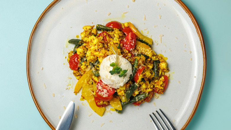 Tofu scramble on a plate with tomatoes and peppers