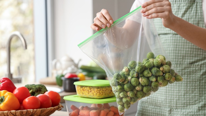 Person holding a bag of Brussels sprouts