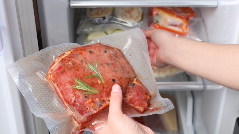 Person putting meat into fridge