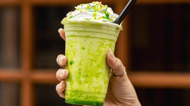 hand holding matcha milkshake