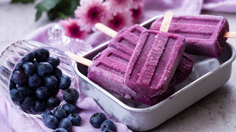 Homemade blueberry popsicles in a pan