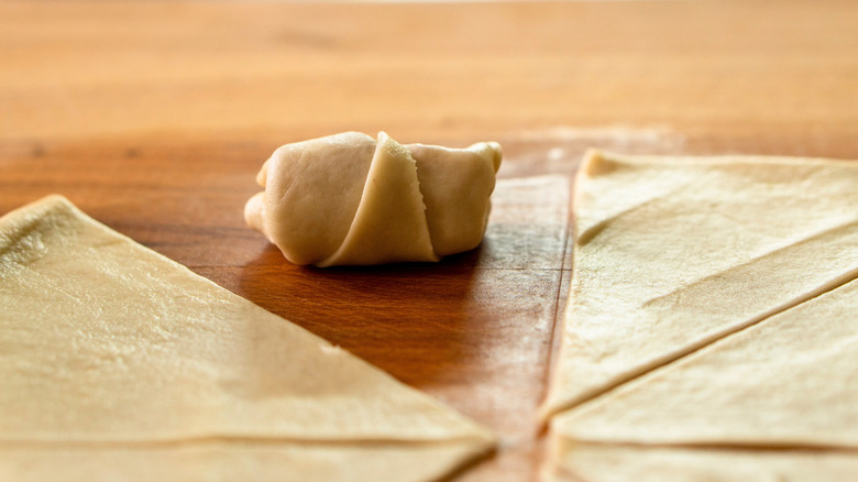 stuffed crescent roll next to unfilled dough pieces