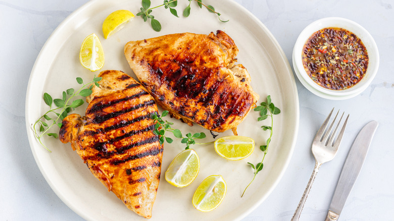 Grilled chicken breast on plate with lemon