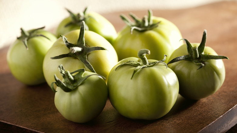 Green tomatoes on wooden board 