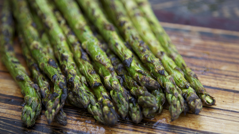 charred asparagus on wooden plate