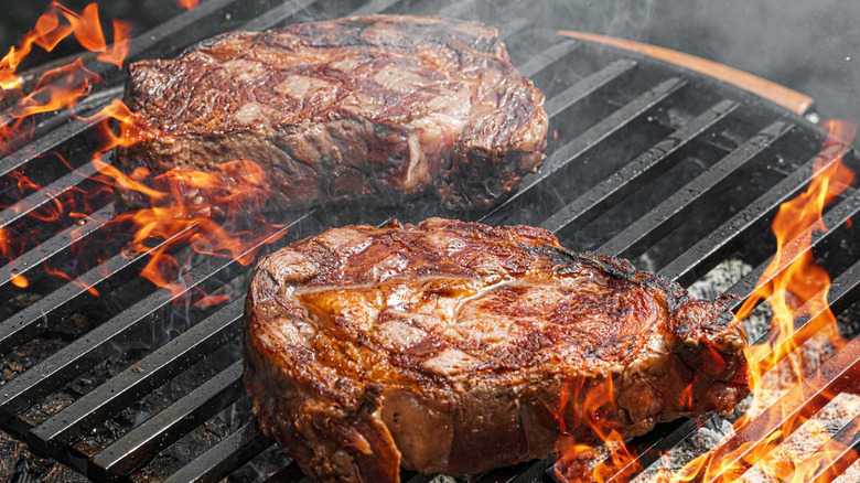 Two thick steaks on charcoal grill