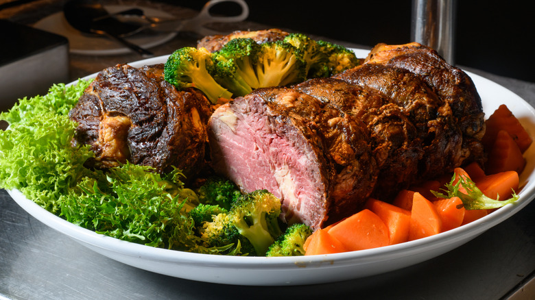 Cooked beef tenderloin on a platter with vegetables