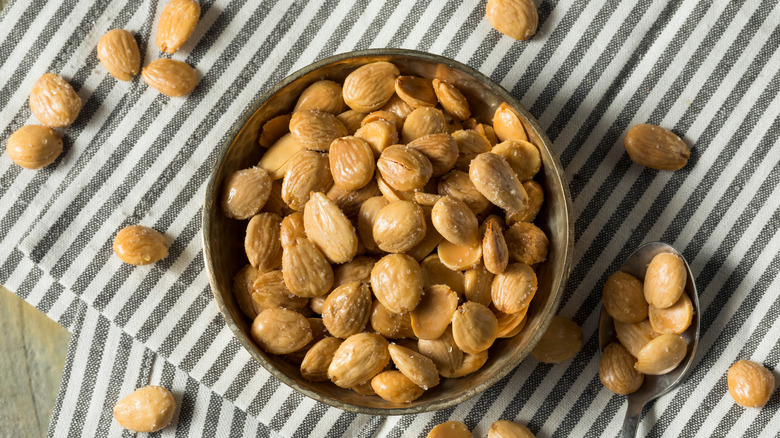 Bowl and spoon of Marcona almonds on striped cloth