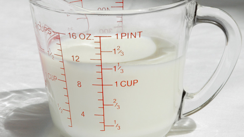 Liquid measuring cup containing milk