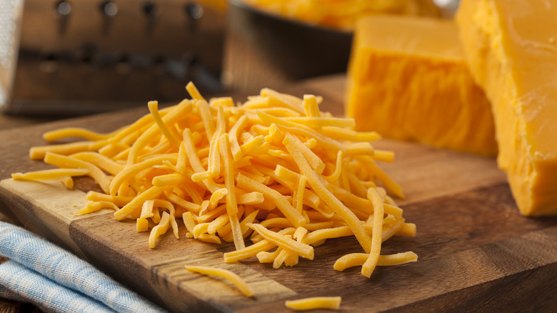 Grated cheddar cheese on board