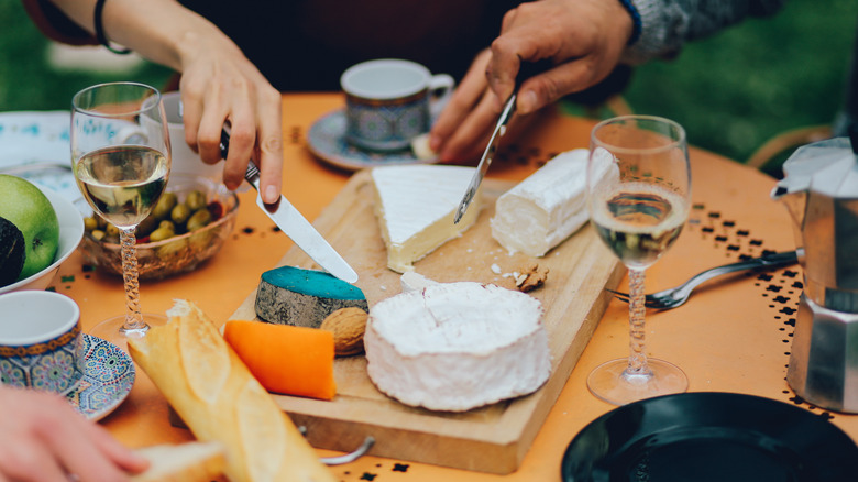 People enjoying cheese board and wine