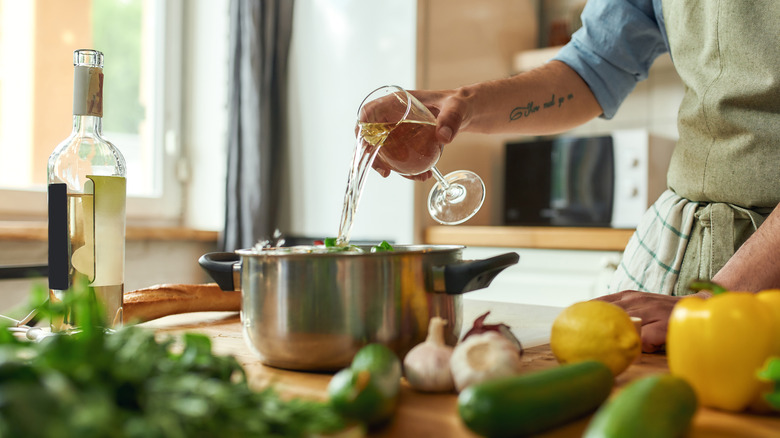 pouring white wine into cooking pan