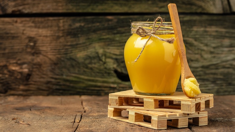 A jar of clarified butter and wooden spoon