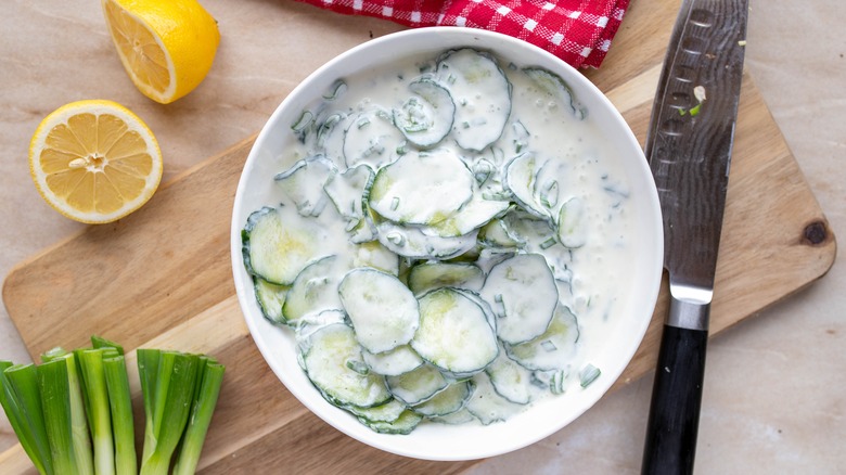 Creamy cucumber salad on serving board