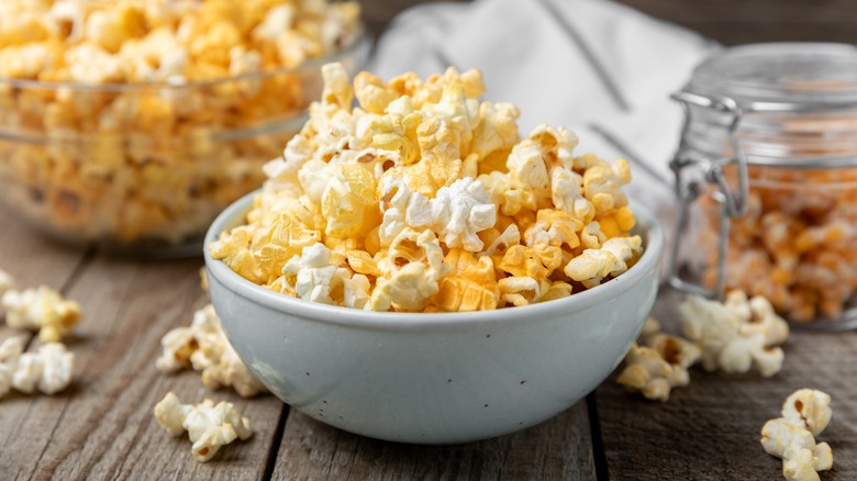 Two bowls of popcorn on wooden background