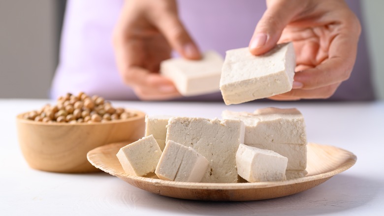 Hands with chunks of tofu